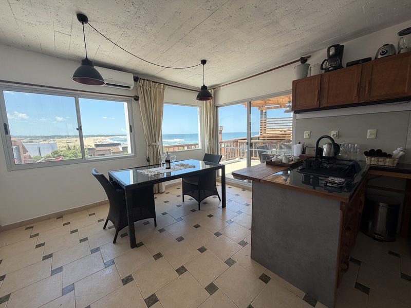 Cocina con isla y vista al mar desde el comedor