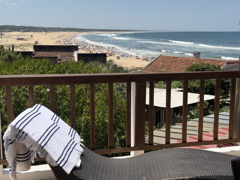 Vista de la playa desde la terraza, con reposera y toalla