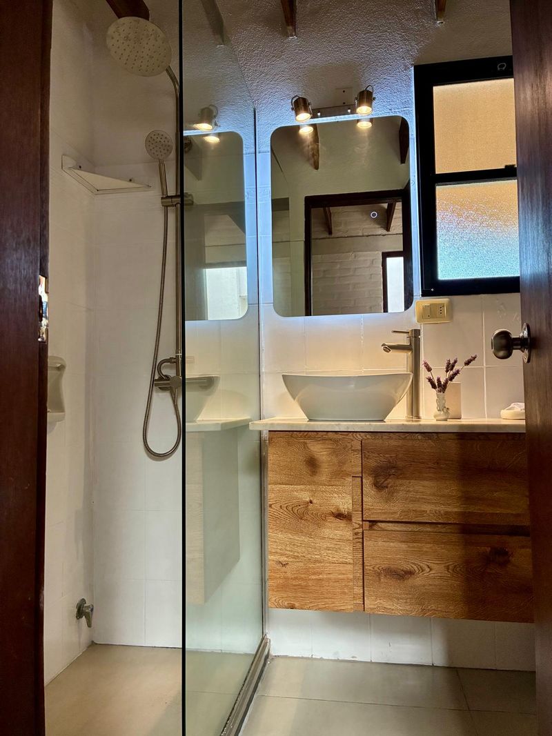 Baño nuevo con ducha vidriada y mesada de madera