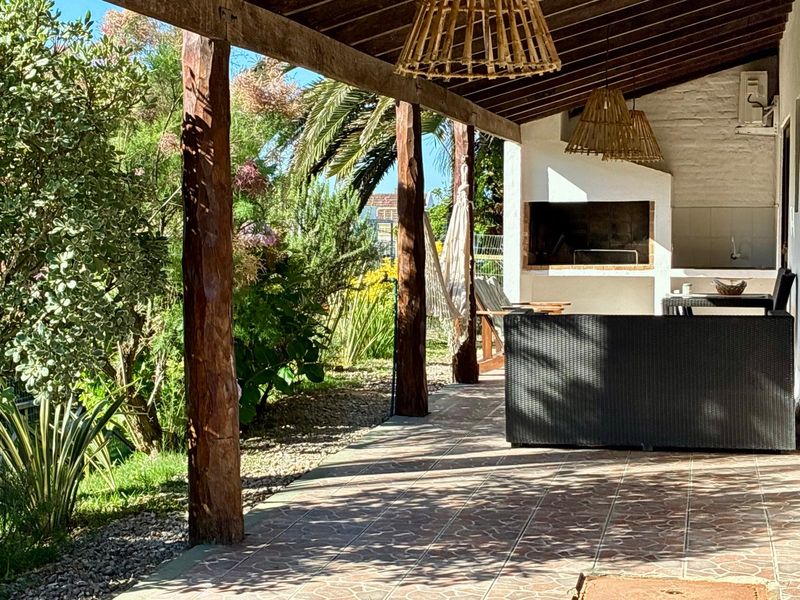 Galería del Estudio Superior con parrillero y pérgola de madera sobre el jardín