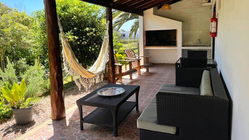 Galería del Estudio con hamaca paraguaya, parrillero techado y jardín