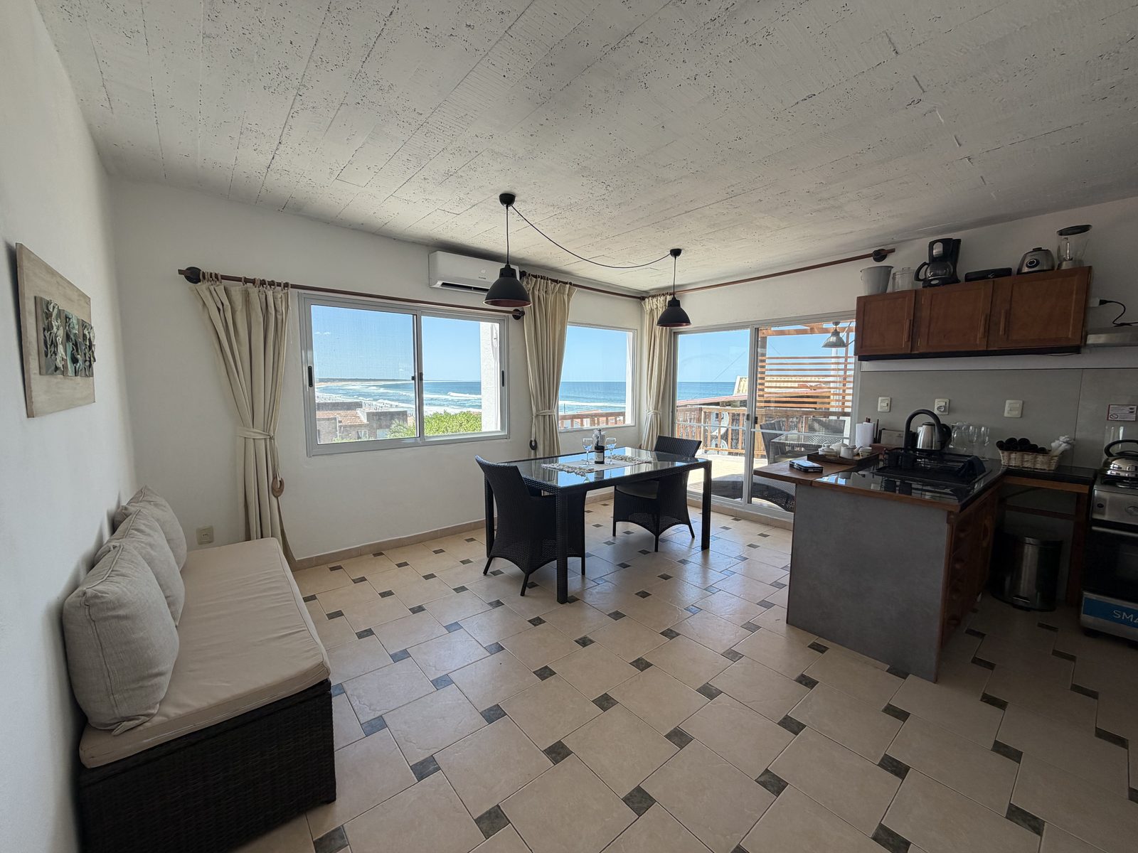El comedor del bungalow de dos dormitorios, con las ventanas mirando al mar