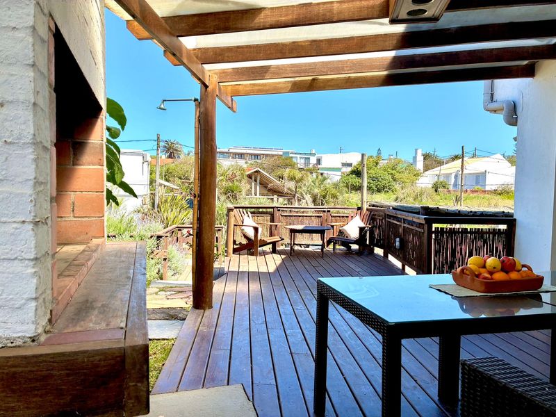 Deck de madera con mesa y parrillero