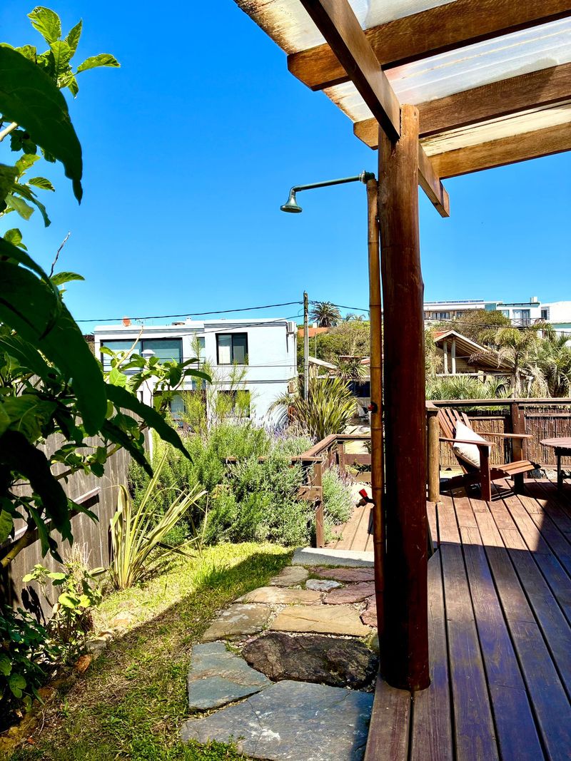 Sector exterior con pérgola de madera y ducha